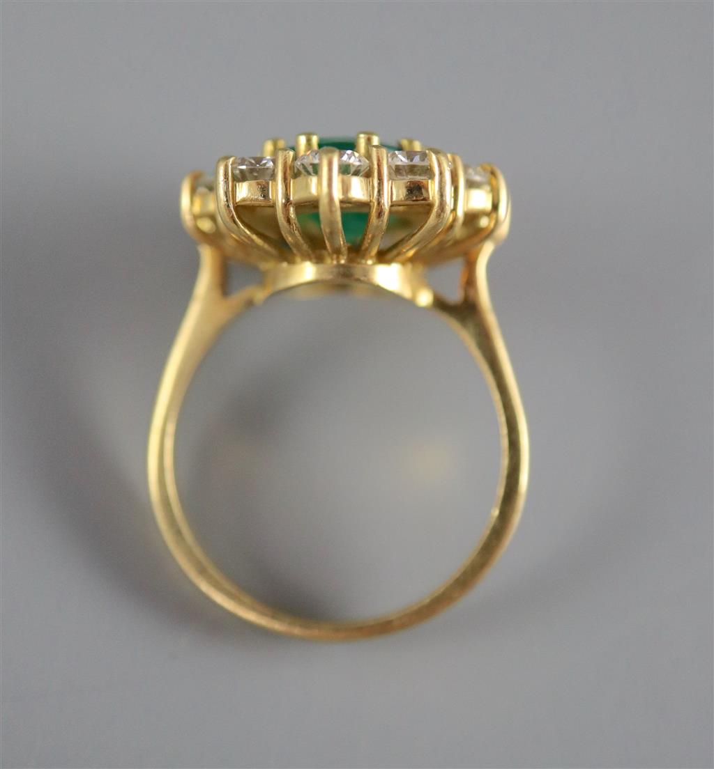 A modern 18ct gold, emerald and diamond oval cluster ring,